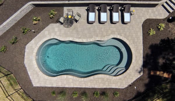 Backyard swimming pool under construction with visible framework and workers.