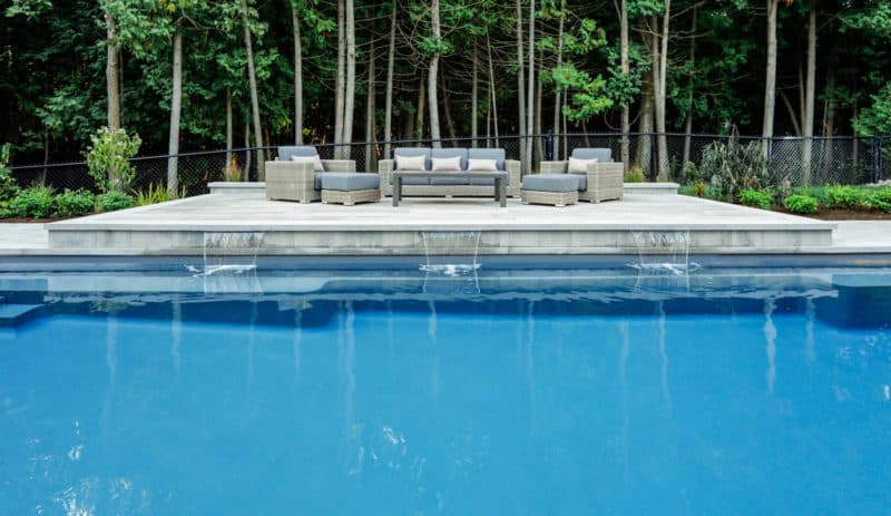 sofa and lunged installed net to a modern dark grey pool